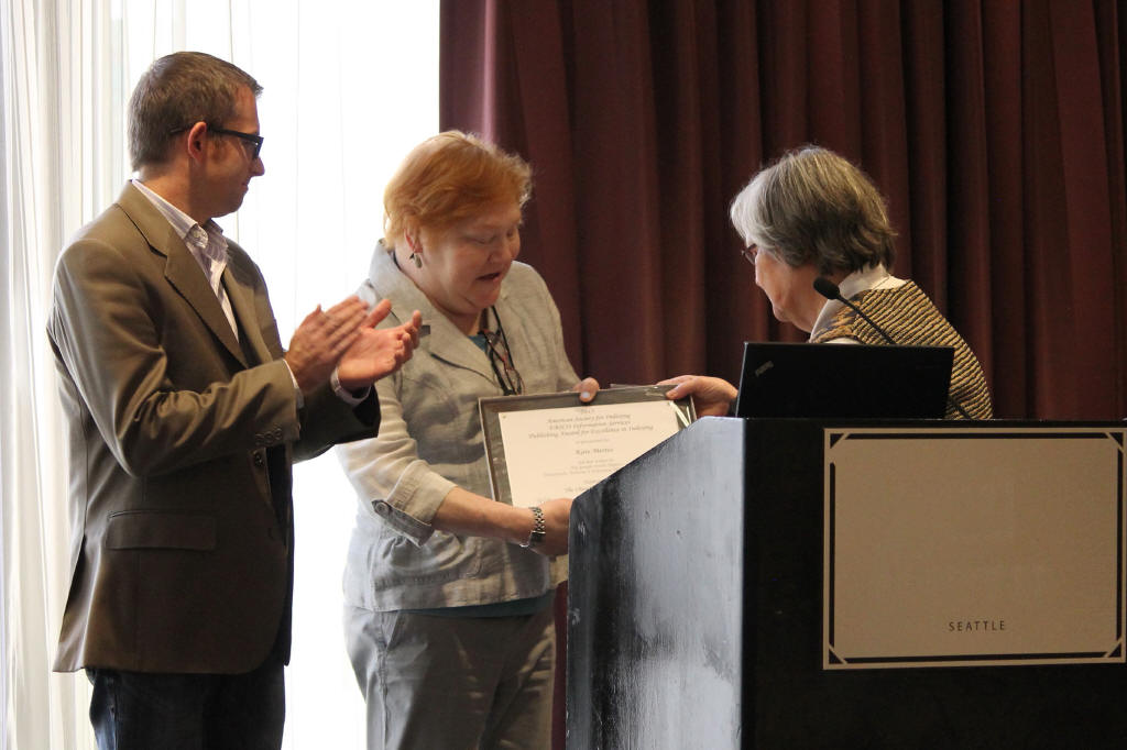 Kate Mertes receives a certificate at a podium